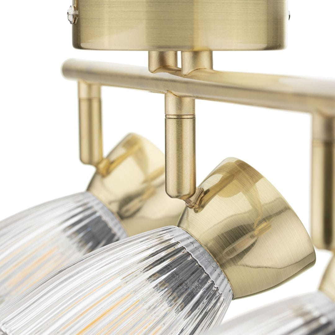 Złota lampa sufitowa (spot) Best z trzema oprawami na żarówki E14. Widok z bliska na metalowy stelaż oraz szklane klosze o żłobionej fakturze, umieszczone w poziomie. Elementy wykonane z metalu, w eleganckim, błyszczącym wykończeniu.