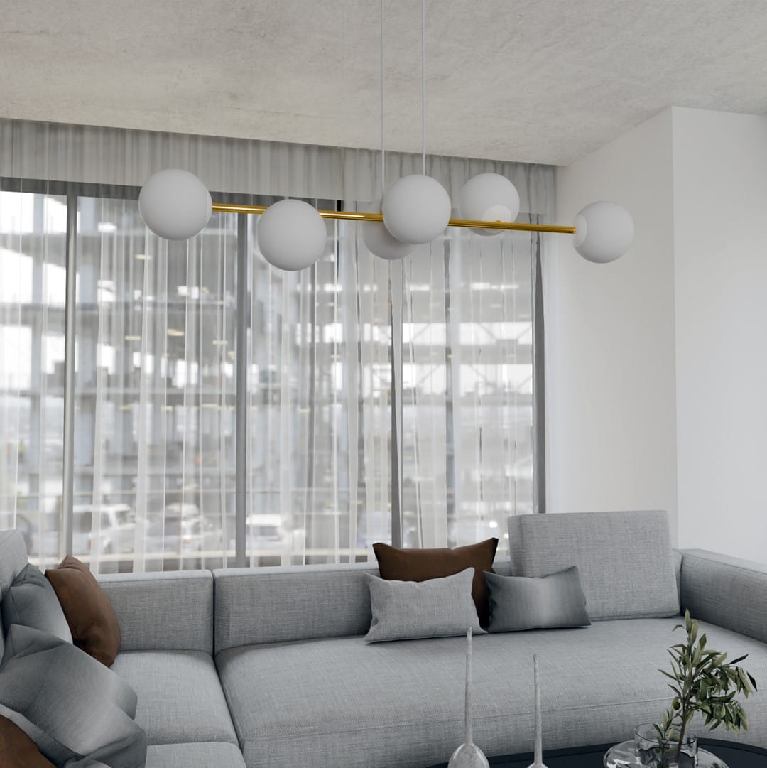 Lampa wisząca Gravity 6-punktowa w kolorze białym i złotym z opalowymi kulami. Zawieszona na prostym, złotym ramieniu, umieszczona nad szaro-beżową sofą, w nowoczesnym wnętrzu z dużymi oknami i delikatnymi zasłonami.