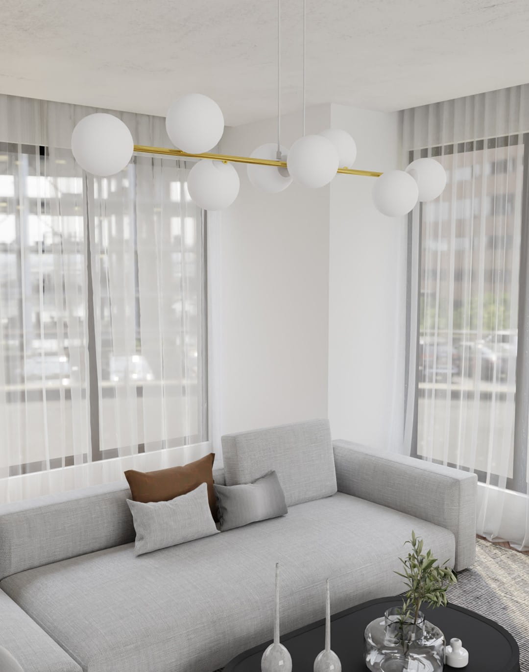 Lampa wisząca Gravity 8-punktowa w białym i złotym kolorze, z opalowymi kloszami. Zawieszona na długim, złotym stelażu, w nowoczesnym wnętrzu z szarym sofą i dużymi oknami. Idealna do oświetlenia przestrzeni dziennej.