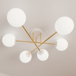 Lampa sufitowa 6-punktowa w kolorze białym i złotym. Okrągłe klosze z białego szkła zawieszone na złotych ramionach, które rozchodzą się promieniście z centralnej podstawy. Ujęcie z dołu, ukazujące elegancki design lampy.
