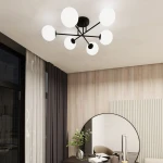 Czarna lampa sufitowa Roma z sześcioma opalowymi kloszami, umieszczona na suficie, z widocznymi łatwymi do zamontowania ramionami. Lampa znajduje się w nowoczesnym wnętrzu z drewnianą ścianą, zasłonami i okrągłym lustrem.