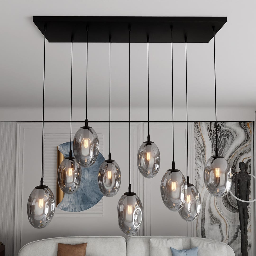 Lampa wisząca Astral 9-punktowa w kolorze czarnym i grafitowym. Składa się z dziewięciu szklanych kloszy w kształcie owalnym, zawieszonych na cienkich linkach. Montowana do sufitu, z widocznymi żarówkami, w nowoczesnym wnętrzu.