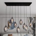 Lampa wisząca Astral 9-punktowa w kolorze czarnym i grafitowym. Składa się z dziewięciu szklanych kloszy w kształcie owalnym, zawieszonych na cienkich linkach. Montowana do sufitu, z widocznymi żarówkami, w nowoczesnym wnętrzu.