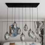 Lampa wisząca Astral 9-punktowa w kolorze czarnym i grafitowym. Składa się z dziewięciu szklanych kloszy o owalnym kształcie, zawieszonych na cienkich linkach. Montaż sufitowy, z prostokątną podstawą. Idealna do nowoczesnych wnętrz.