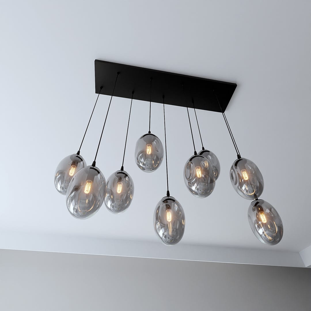 Czarna lampa wisząca Astral z dziewięcioma szklanymi kloszami o owalnym kształcie, zawieszona na cienkich kablach. Klosze mają ciemne, lekko przezroczyste wykończenie, w których widoczne są żarówki. Całość montowana na prostokątnej podstawie.