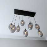 Czarna lampa wisząca Astral z dziewięcioma szklanymi kloszami o owalnym kształcie, zawieszona na cienkich kablach. Klosze mają ciemne, lekko przezroczyste wykończenie, w których widoczne są żarówki. Całość montowana na prostokątnej podstawie.