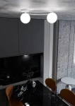 Lampa sufitowa Sopra 2-punktowa w kolorze białym z opalowymi kloszami, zamontowana na suficie. Klosze w kształcie kul, umieszczone na okrągłej podstawie. Tło w aranżacji kuchennej z czarnym blatem i szarymi szafkami.