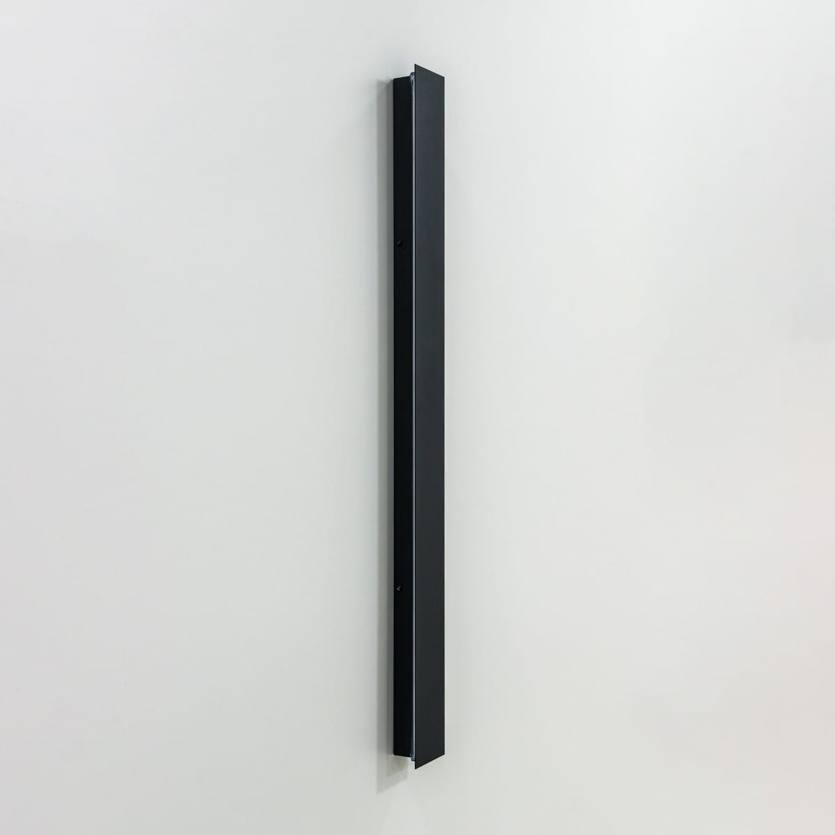 Kinkiet zewnętrzny Mutti 3K w kolorze czarnym, o prostokątnym kształcie, wykonany z metalu. Ujęcie z boku, montowany na ścianie, z widocznymi otworami do mocowania. Oświetlenie LED, 3x9W, 3000K. Tło jasne, jednolite.