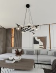 Lampa wisząca Essa 8-punktowa w kolorze czarnym z przezroczystymi kloszami, zamontowana na suficie. Klosze w formie kul, zawieszone na cienkich linkach, w nowoczesnym wnętrzu z jasnymi meblami i dekoracjami.