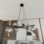 Lampa wisząca Essa 8-punktowa, czarna i grafitowa, z ośmioma przezroczystymi kulami, zawieszona na cienkich linkach. Kule z widocznymi żarówkami w środku, umieszczone na poziomej belce. Lampa montowana sufitowo, w nowoczesnym wnętrzu.