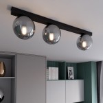 Fit lampa sufitowa 3-punktowa w kolorze czarnym i grafitowym, z trzema okrągłymi kloszami w odcieniu szaro-srebrnym. Zawieszona poziomo pod sufitem w nowoczesnym wnętrzu, na tle szafek w odcieniach szarości i zieleni.