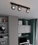 Lampa sufitowa 3-punktowa w kolorze czarnym i grafitowym, z trzema metalowymi kulami o błyszczącej powierzchni, zamontowana na prostokątnej podstawie. Widoczna w nowoczesnym wnętrzu, oświetlająca przestrzeń nad biurkiem.
