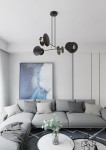 Lampa wisząca czarna, 4-punktowa, z okrągłymi kloszami, zawieszona na cienkich linkach. Ujęcie z dołu, w nowoczesnym wnętrzu z szaro-białymi akcentami, w tle obraz w stonowanej kolorystyce.