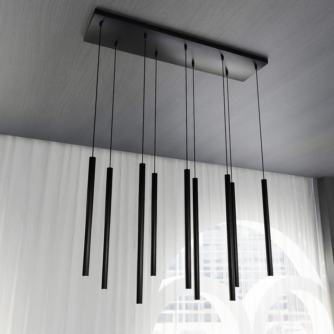 Czarna lampa wisząca Selter 9-punktowa z prostokątnym stelażem, z dziewięcioma wydłużonymi, cylindrycznymi kloszami zwisającymi na cienkich linkach. Ujęcie z dołu, na tle jasnej zasłony.