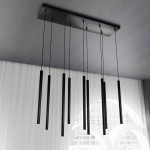 Czarna lampa wisząca Selter 9-punktowa z prostokątnym stelażem, z dziewięcioma wydłużonymi, cylindrycznymi kloszami zwisającymi na cienkich linkach. Ujęcie z dołu, na tle jasnej zasłony.