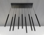 Lampa wisząca Selter 9-punktowa, czarna, z długimi, cylindrycznymi kloszami, zawieszona na cienkich linkach. Ujęcie z góry, ukazujące równomierne rozmieszczenie punktów świetlnych na prostokątnej podstawie. Tło w jasnym kolorze.