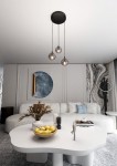 Lampa wisząca Cosmo Premium 3-punktowa w kolorze grafitowym, zawieszona na trzech cienkich linkach, z transparentnymi kloszami. Widoczna w nowoczesnym wnętrzu z sofą i dekoracjami, na jasnym tle.