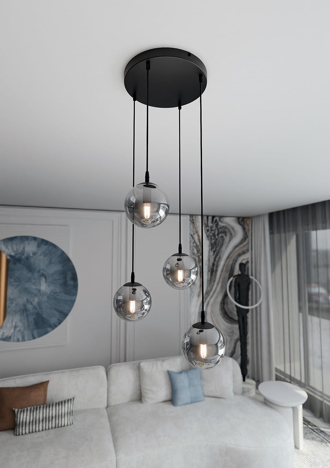Grafitowa lampa wisząca Cosmo Premium z czterema szklanymi kulami, zawieszona na czarnych linkach. Kule mają przezroczyste, lekko przyciemnione szkło, z widocznymi żarówkami. Ujęcie z góry, w nowoczesnym wnętrzu z jasną kanapą i dekoracjami.