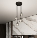 Grafitowa lampa wisząca Cosmo Premium z czterema szklanymi kloszami, zawieszona na cienkich linkach. Klosze mają okrągły kształt, a wewnątrz widoczne są żarówki. Lampa umieszczona w nowoczesnym wnętrzu z marmurowymi detalami.