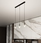 Lampa wisząca Cosmo 3-punktowa z transparentnymi, okrągłymi kloszami, zawieszona na czarnych linach. Zawieszenie na prostokątnej podstawie, w tle widoczna marmurowa ściana i ciemne meble.