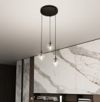 Lampa wisząca Cosmo Premium 3-punktowa z przezroczystymi kulistymi kloszami, zawieszona na czarnych linkach. Montowana do sufitu, w otoczeniu nowoczesnej aranżacji z marmurowymi i drewnianymi elementami.