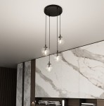 Lampa wisząca Cosmo Premium 4-punktowa z przezroczystymi kloszami, zawieszona na czarnych linkach. Klosze w kształcie kul, emitujące światło, umieszczone na okrągłej podstawie sufitowej. Tło w odcieniach szarości z marmurowymi i drewnianymi elementami.