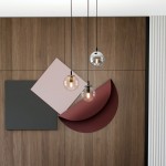 Lampa wisząca Cosmo Premium 3-punktowa w kolorach multikolorowych. Składa się z trzech okrągłych kloszy w różnych odcieniach, zawieszonych na cienkich, czarnych linkach. W tle widoczne geometryczne dekoracje na drewnianej ścianie.