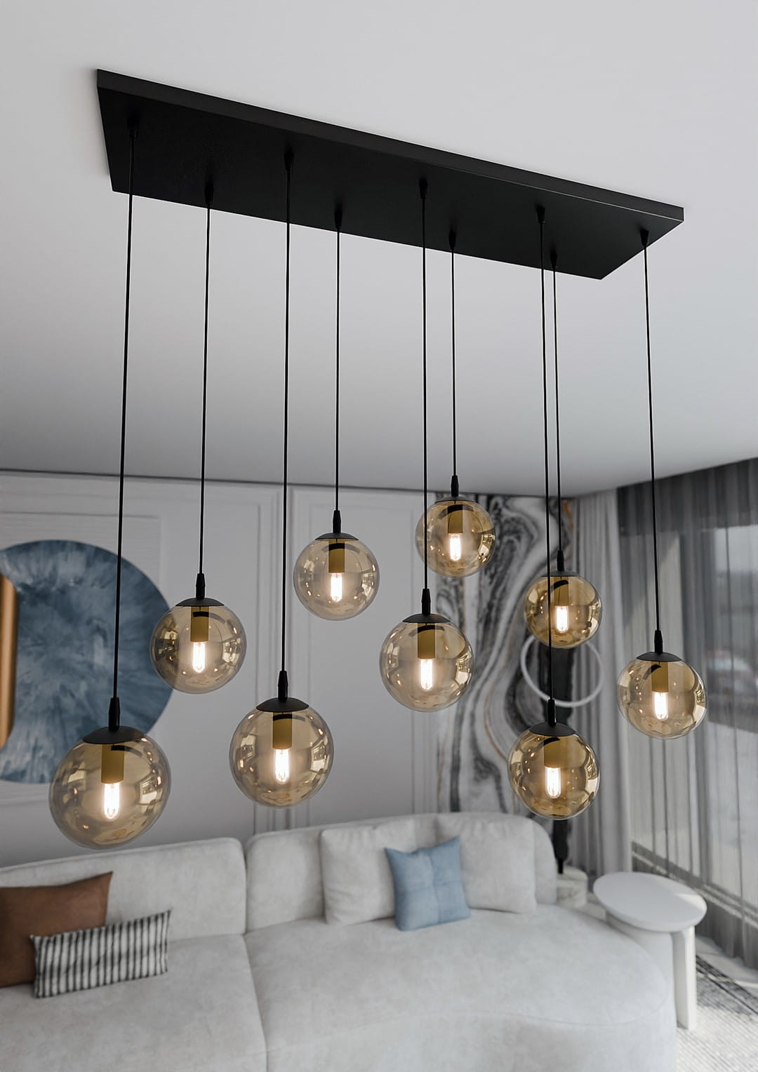 Lampa wisząca Cosmo 9-punktowa w kolorze miodowym, składająca się z dziewięciu okrągłych kloszy. Klosze mają przezroczysty, szklisty wygląd, zawieszone na cienkich czarnych przewodach z metalową podstawą.