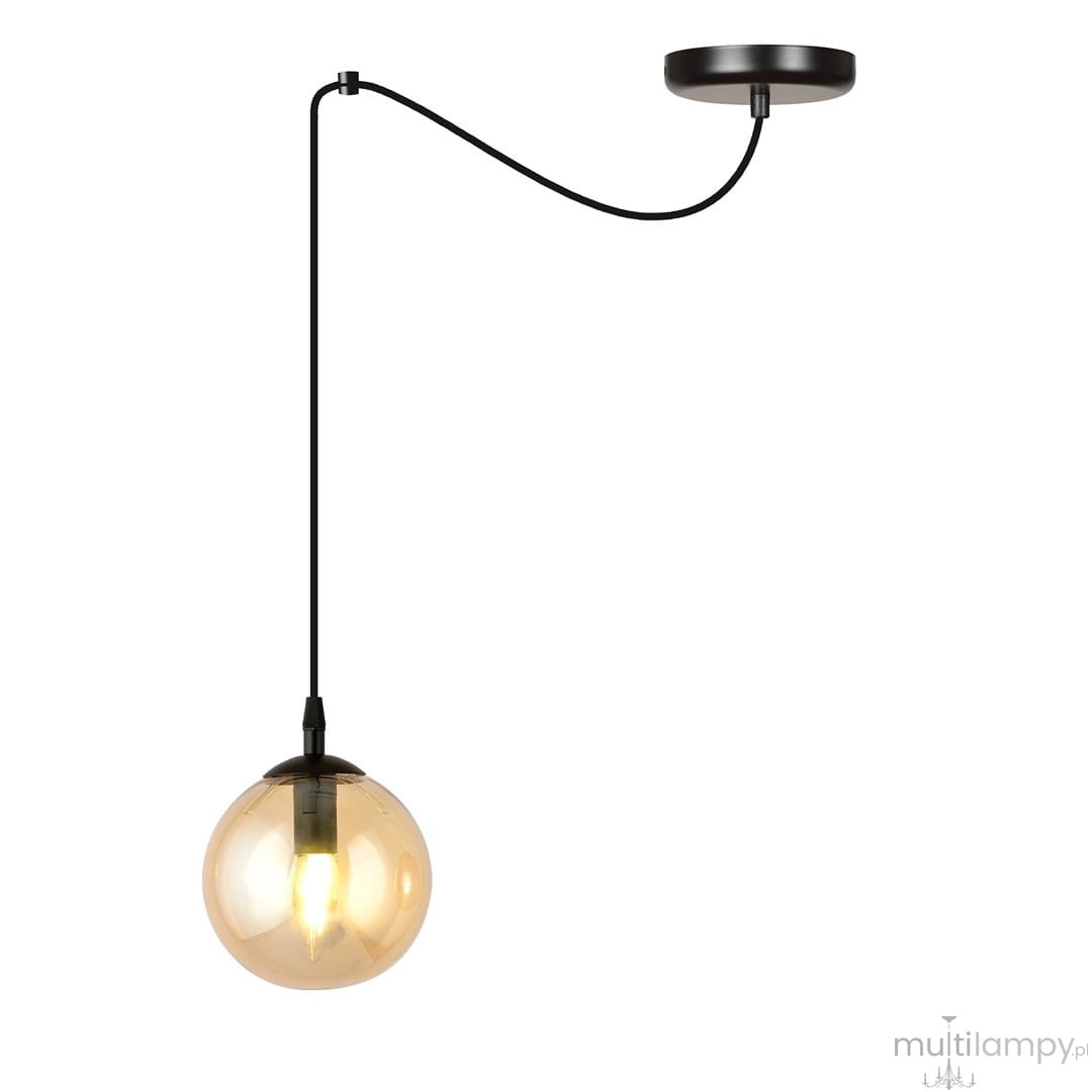 Lampa wisząca Gigi 1-punktowa w kolorze miodowym z przezroczystą kulistą osłoną. Zawieszona na czarnym przewodzie, z metalowym mocowaniem sufitowym. Kształt: kulisty, materiał: szkło. Ujęcie frontalne, na jednolitym tle.