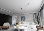 Lampa wisząca Gigi 5-punktowa w multikolorze, zawieszona na czarnych przewodach. Posiada pięć szklanych kloszy w różnych odcieniach. Ujęcie z góry, pokazujące lampę w nowoczesnym wnętrzu z białymi meblami oraz dekoracyjnymi elementami.