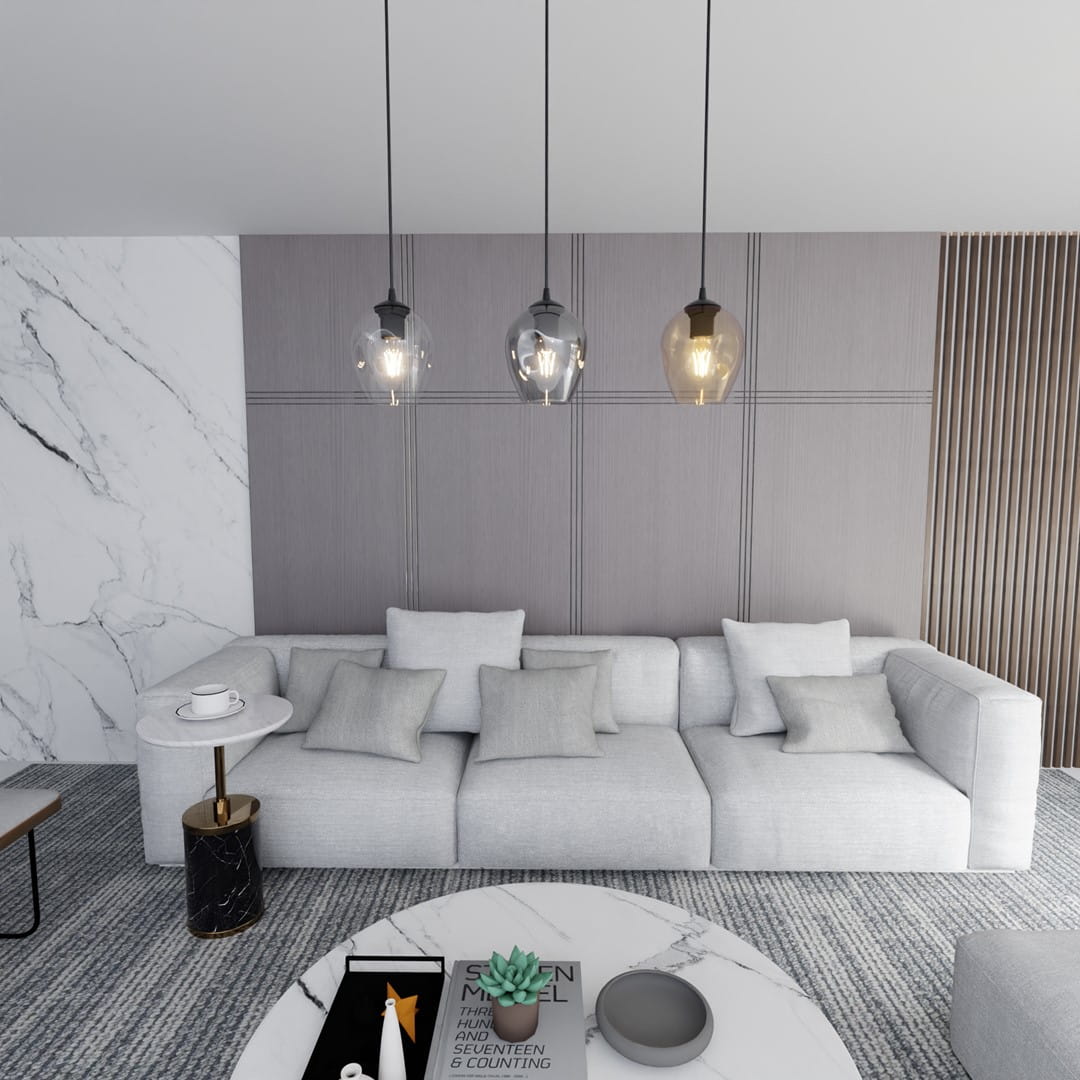 Lampa wisząca Istar mix 3-punktowa 678/3 z przezroczystymi kloszami w różnych odcieniach, zawieszona nad szarym, narożnym sofą z poduszkami. Elementy metalowe w kolorze czarnym i złotym, w nowoczesnym wnętrzu z marmurowym stołem i dekoracjami.