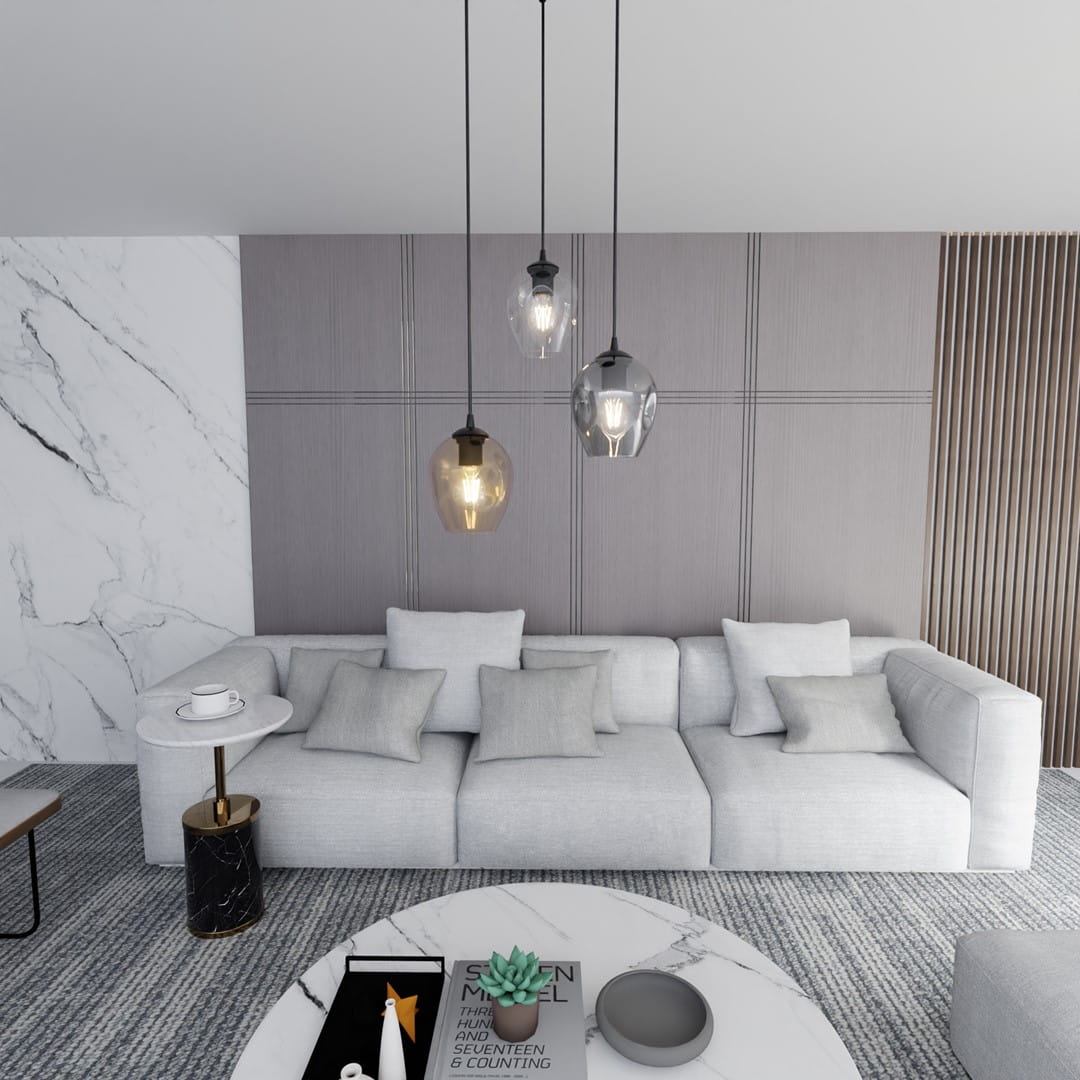 Lampa wisząca Istar Premium mix 3-punktowa, z trzema szklanymi kloszami w różnych kolorach: przezroczystym, szarym i brązowym, zawieszona nad jasną sofą. Tło z szarymi panelami i marmurowym blatem stołu.