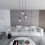 Lampa wisząca Istar Premium mix 3-punktowa, z trzema szklanymi kloszami w różnych kolorach: przezroczystym, szarym i brązowym, zawieszona nad jasną sofą. Tło z szarymi panelami i marmurowym blatem stołu.