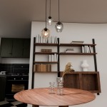 Lampa wisząca 3-punktowa Istar Premium mix z trzema szklanymi kloszami w różnych kolorach (przezroczysty, brązowy, czarny), zawieszona nad okrągłym drewnianym stołem, w nowoczesnej kuchni z otwartymi półkami i akcesoriami.