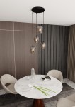 Lampa wisząca Istar Premium 4-punktowa w kolorze grafitowym, składająca się z czterech szklanych kloszy, zawieszona na czarnych linkach, umieszczona nad okrągłym stołem z marmurowym blatem w nowoczesnym wnętrzu.