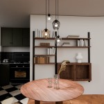 Lampa wisząca Istar Premium mix 4-punktowa z różnymi kloszami w kształcie kul oraz szklanym i metalowym wykończeniem, zawieszona nad okrągłym drewnianym stołem, w nowoczesnej aranżacji kuchni z półkami na książki w tle.