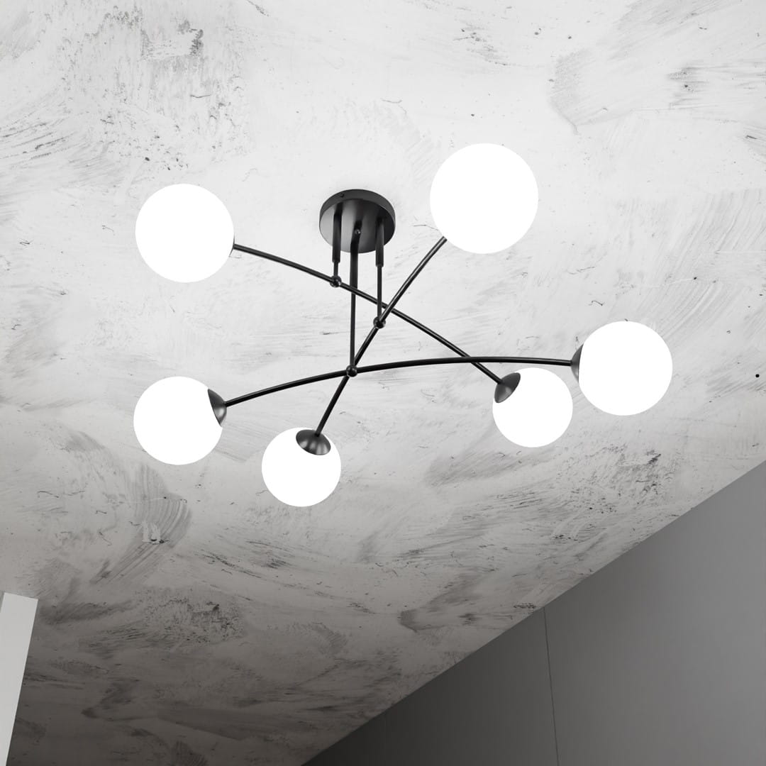 Sufitowa lampa Pregos z sześcioma białymi okrągłymi kloszami na czarnych ramionach, montowana na suficie. Widok z dołu, ukazujący nowoczesny design i równomierne rozmieszczenie źródeł światła. Tło w odcieniach szarości.