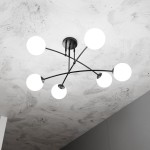 Sufitowa lampa Pregos z sześcioma białymi okrągłymi kloszami na czarnych ramionach, montowana na suficie. Widok z dołu, ukazujący nowoczesny design i równomierne rozmieszczenie źródeł światła. Tło w odcieniach szarości.