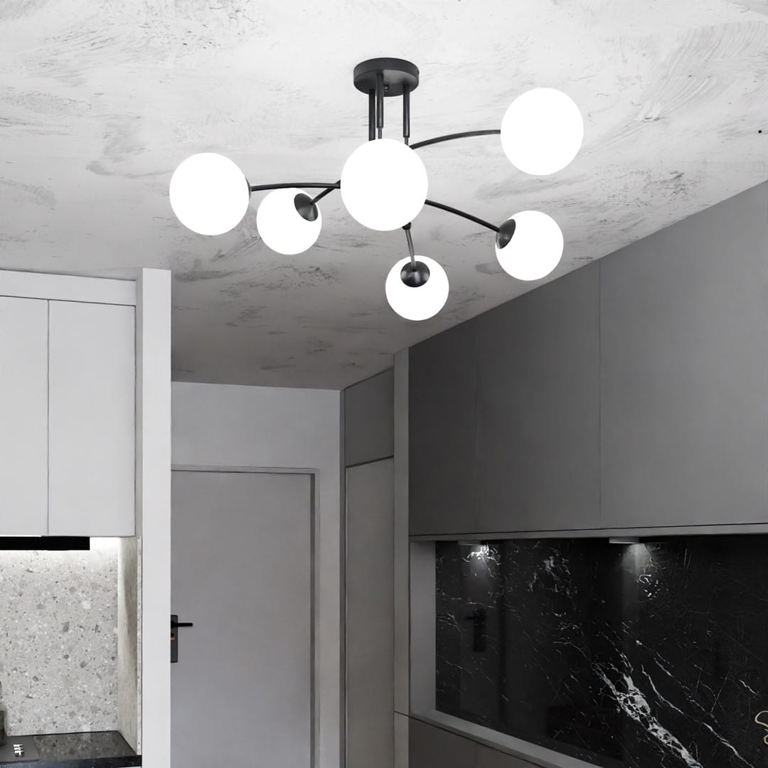 Czarna lampa sufitowa Pregos 6-punktowa z sześcioma białymi kulistymi kloszami, zamontowana na suficie. Lampa ma nowoczesny, minimalistyczny design, idealna do wnętrz. Widoczna w kuchennej aranżacji z szarymi meblami i kamiennym blatem.
