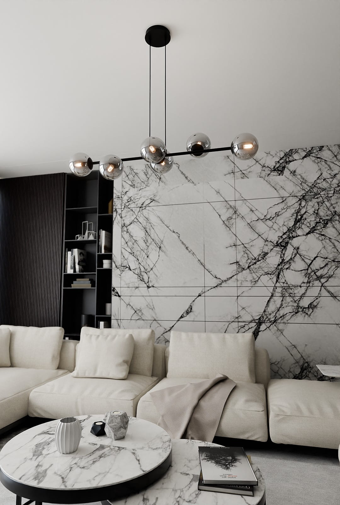 Lampa wisząca Rossi 6-punktowa w kolorze czarnym i grafitowym, z sześcioma okrągłymi kloszami w metalicznym wykończeniu. Zawieszona na cienkich linkach, w nowoczesnym wnętrzu z jasnymi sofami i marmurowymi stolikami, na tle ściany z wzorem marmuru.