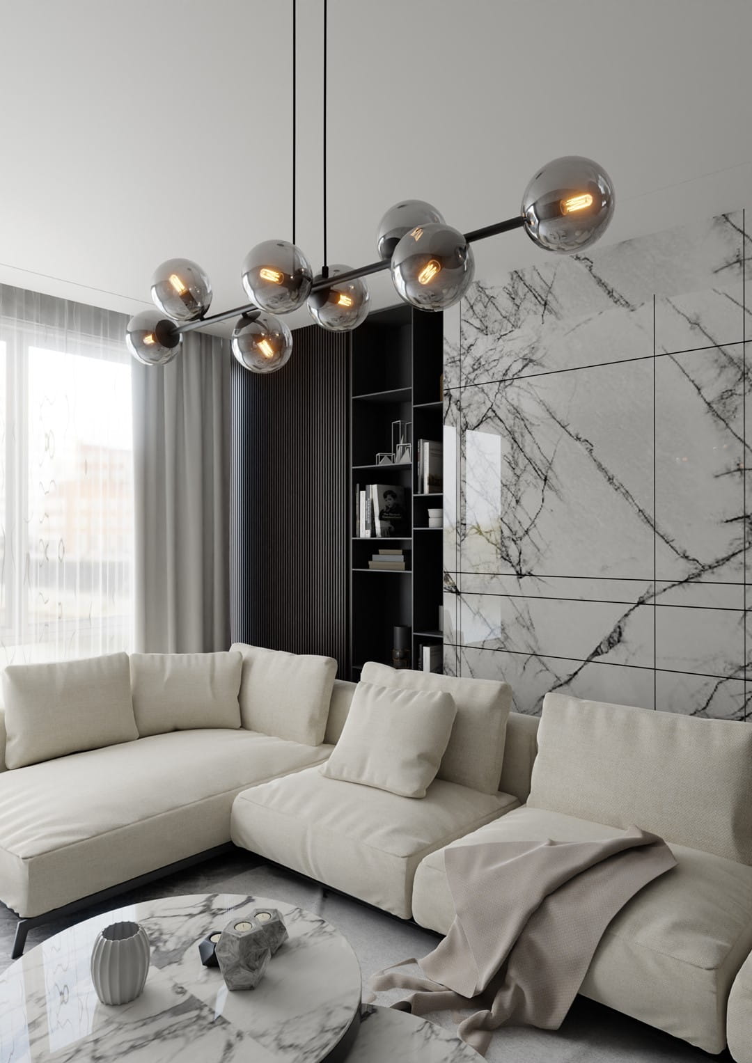 Lampa wisząca Rossi 8-punktowa w kolorze czarnym i grafitowym, z ośmioma szklanymi kulami na metalowej konstrukcji, wisi nad jasną sofą. W tle widoczna jest nowoczesna aranżacja wnętrza z marblowymi płytkami.