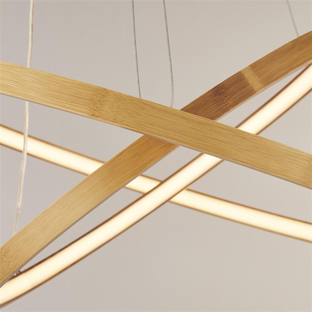 Lampa wisząca Eternity z naturalnego bambusa w złotym kolorze, z dwoma paskami LED. Ujęcie z bliska ukazuje stylowe, zakrzywione elementy konstrukcji oraz ciepłe światło emitowane przez diody.