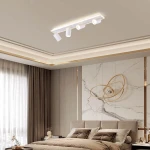 Lampa sufitowa Parma w kolorze białym, montowana na suficie, z czterema ruchomymi punktami świetlnymi GU10 i jednym LED. Zastosowanie w nowoczesnych wnętrzach, w otoczeniu eleganckiego wystroju sypialni z szarymi zasłonami i jasnymi ścianami.