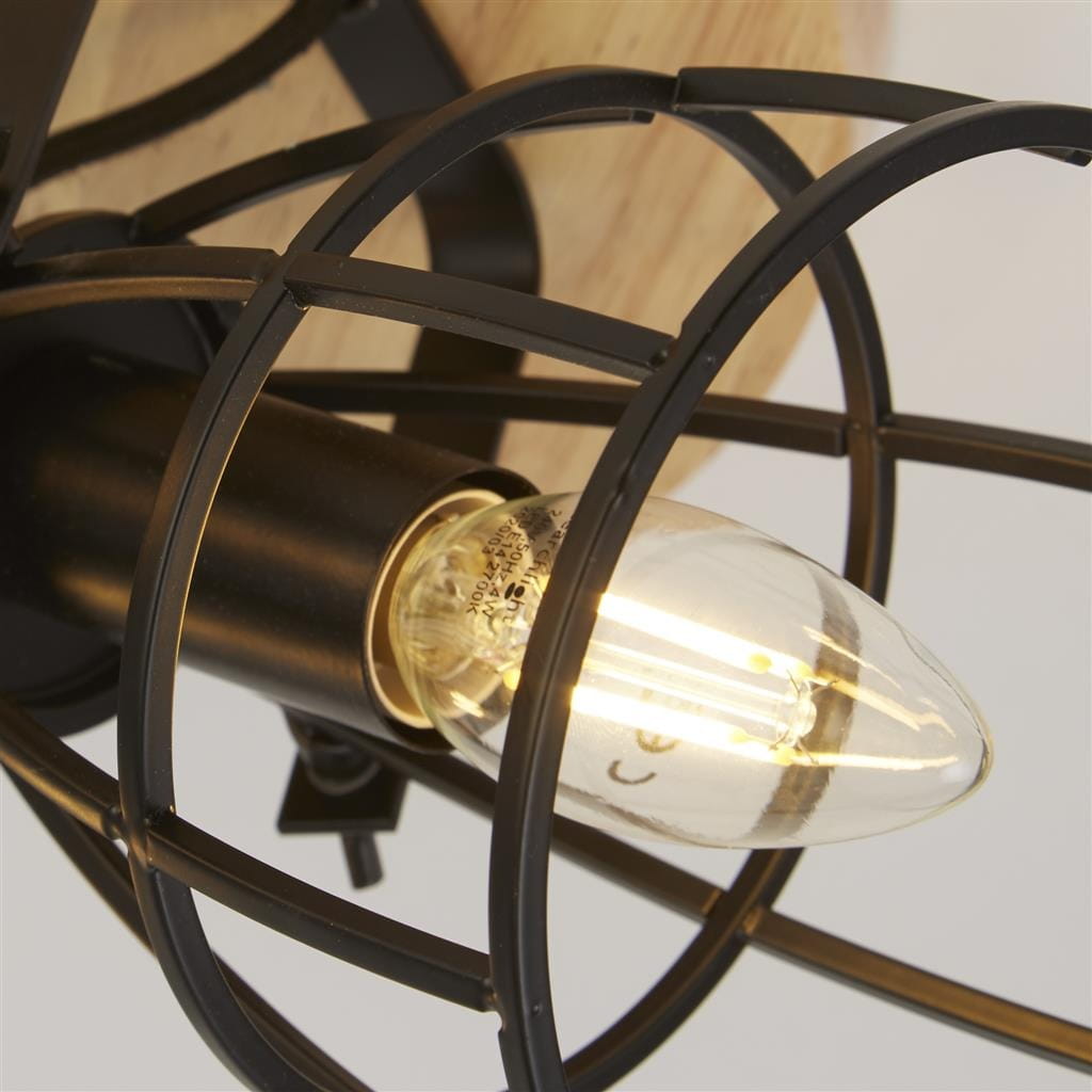 Lampa sufitowa Vision z trzema oprawami E14, wykonana z czarnego metalu z drewnianym elementem. Ujęcie z bliska pokazuje żarówkę w metalowej klatce, na tle jasnego drewna. Idealna do nowoczesnych wnętrz.