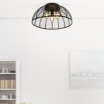 Czarna lampa sufitowa Vision z trzema oprawkami E27, o okrągłym, siatkowym kloszu, zamontowana na białym tle. Ujęcie z dołu, ukazujące stylowy design i źródła światła wewnątrz klosza. W tle widoczna półka z książkami i dekoracjami.