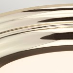 Plafon Welland z mosiądzu, zbliżenie na obrzeże. Wysoka połyskliwość, gładka powierzchnia. Kształt okrągły, z delikatnymi liniami. Element przeznaczony do montażu sufitowego, IP54, 1xLED/25W. Tło jednolite, jasne.