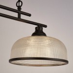Czarna lampa wisząca Highworth z podwójnym mocowaniem E27. Okrągły, przezroczysty klosz z teksturowanego szkła, metalowa konstrukcja z widocznymi rurkami, zawieszona na łańcuchu. Wymiary i detale konstrukcji podkreślają nowoczesny styl.
