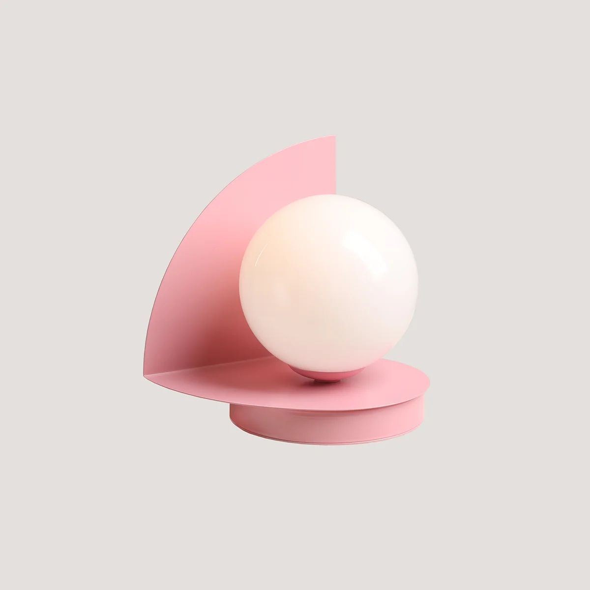 Lampa stołowa Loop Baby Pink z okrągłą, białą kulą na różowej podstawie i półokrągłym ekranem. Ujęcie z boku, ukazuje nowoczesny design. Idealna do aranżacji wnętrz.