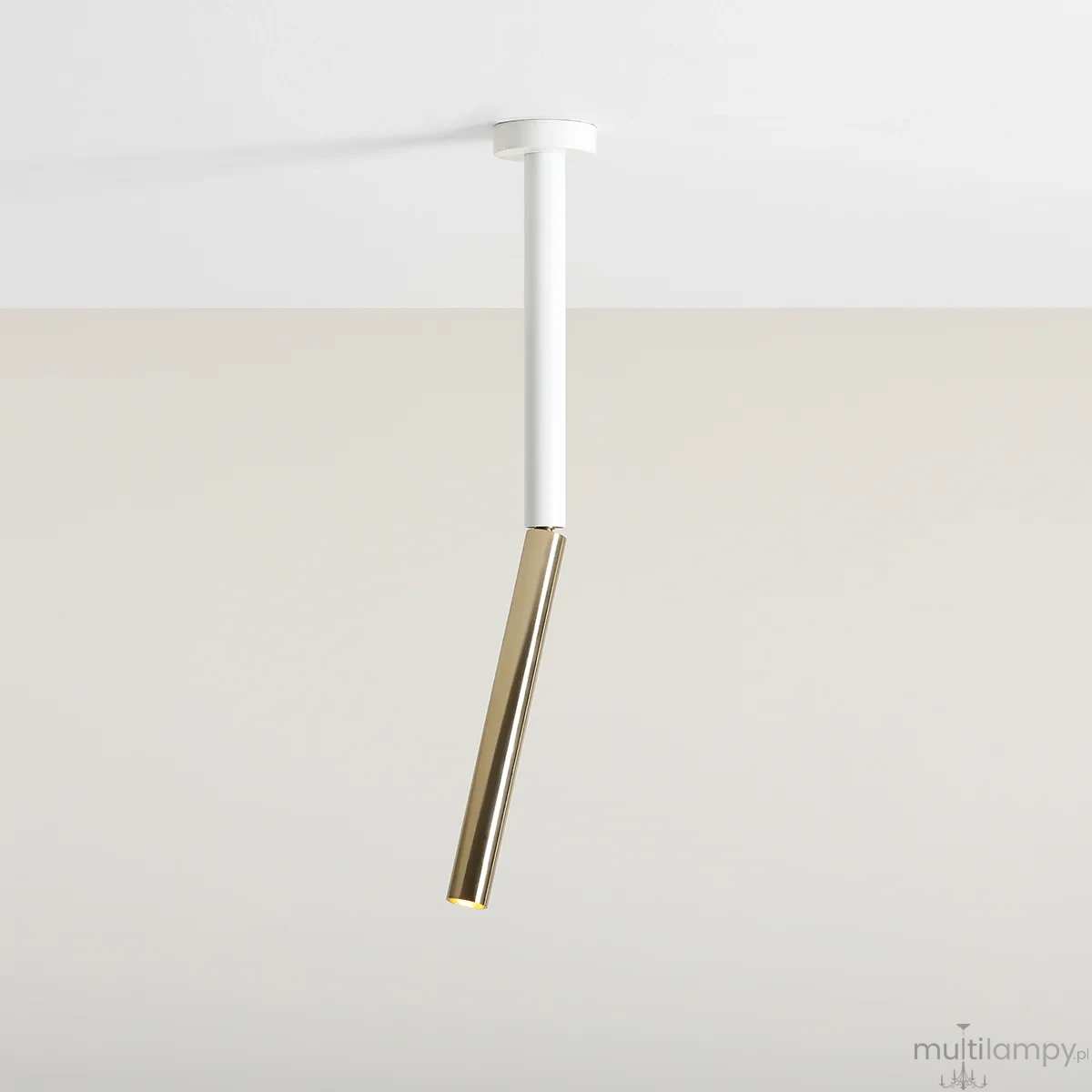 Lampa sufitowa Stick S o białym, prostokątnym korpusie i złotym, cylindrycznym kloszu. Ujęcie z dołu, zawieszona pod sufitem. Prosty, nowoczesny design, idealna do minimalistycznych wnętrz.