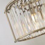 Lampa wisząca Victoria w antycznym mosiądzu, z pięcioma gniazdami E27. Ozdobiona przezroczystymi, prostokątnymi kryształami, tworzy efektowne refleksy świetlne. Ujęcie z boku, ukazujące detale konstrukcji i elementy mocujące.